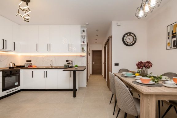 Modern kitchen and dining area with a table set for meals and stylish decor.